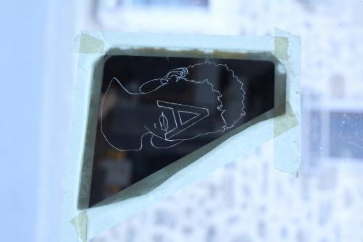 miroir gravé d'un visage et d'une lettre.