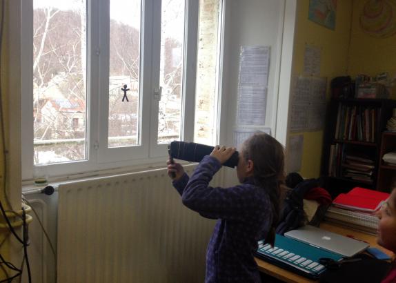 Romane observe la silhouette inversée du bonhomme scotché sur la vitre 