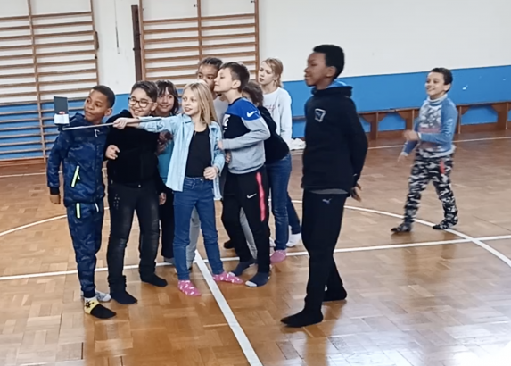 Une enfant tient un miroir à bout de bras, les autres suivent leur reflet dans le miroir