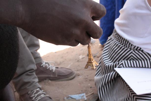 "Badar Ndiaye me troque un porte-clef en forme de Tour Eiffel. Il lui semble évident de me le donner. Lorsque je lui demande pourquoi il m’échange cet objet, il me répond. « C’est Paris ! » La Tour Eiffel est-elle une image de la France qui doit retourner en France ? Une image qui m’appartient, à moi, une femme blanche venant de « Paris, Paris, ce petit coin de Paradis » (avec toute l’ironie de Joséphine Baker)."