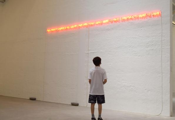 Noa devant l'œuvre de Joseph Kosuth