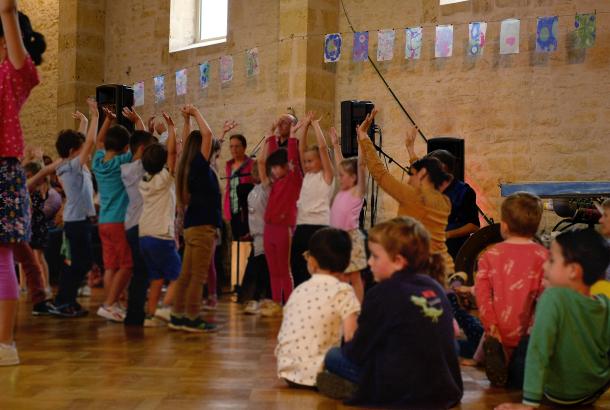 Les enfants dansant dans le temple protestant qui sert ici de salle des fêtes. Les fanions sont en arrière plan.