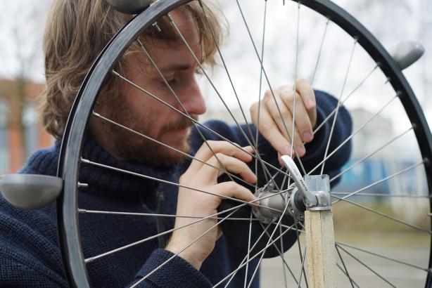 Tom qui visse des vis dans une roue de vélo