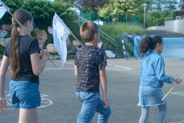 Les élèves défilent avec les drapeaux