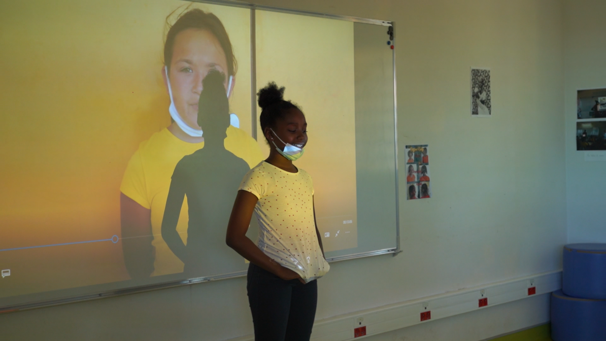 Dynjie présentant les autoportraits vidéos des filles de la classe
