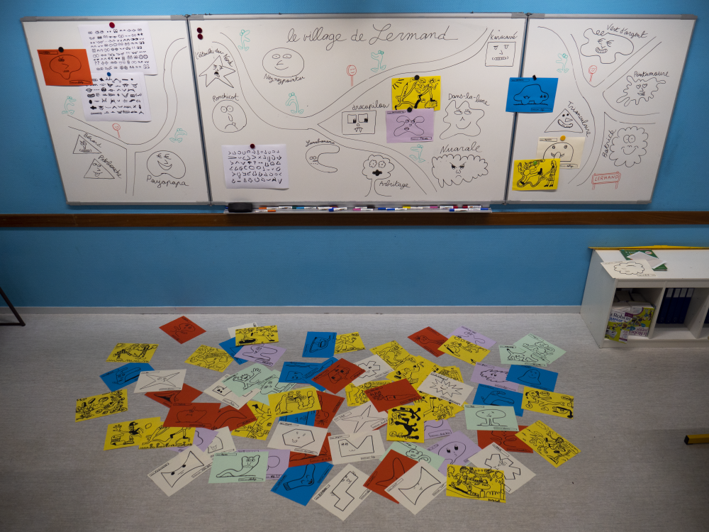 Accrochage dans la salle de classe des dessins produits pendant la première semaine.