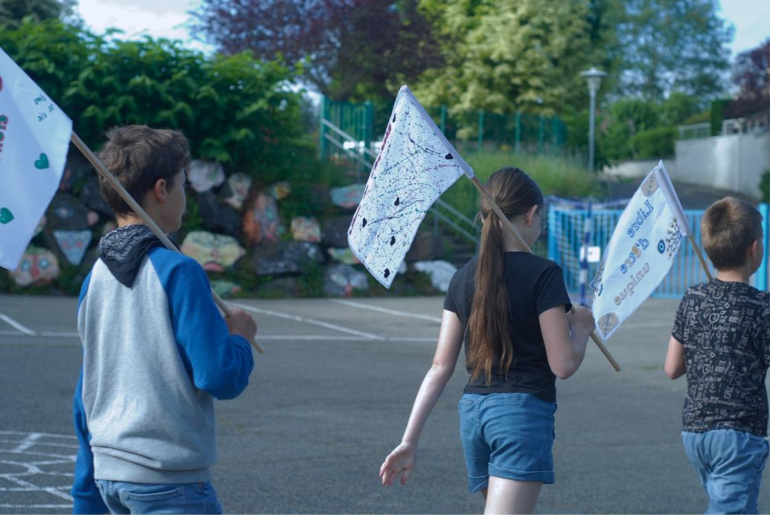 Les élèves défilent avec les drapeaux