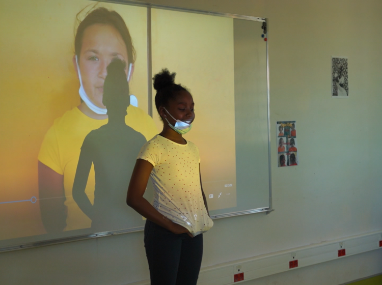Dynjie présentant les autoportraits vidéos des filles de la classe