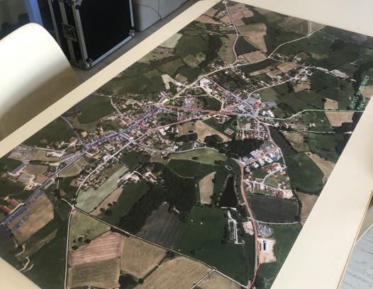 carte satellite imprimée sur bâche représentant Marcillat-en-Combraille avec les trajets des enfants vers l'école.