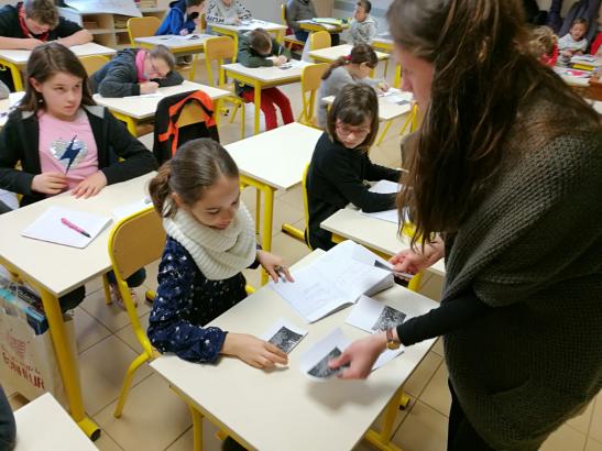 Cahiers d'expression écrite sur la table, images sous les yeux, les élèves se lancent dans une rédaction libre de ce qu'ils souhaitent allier aux images © Mathieu Moncomble