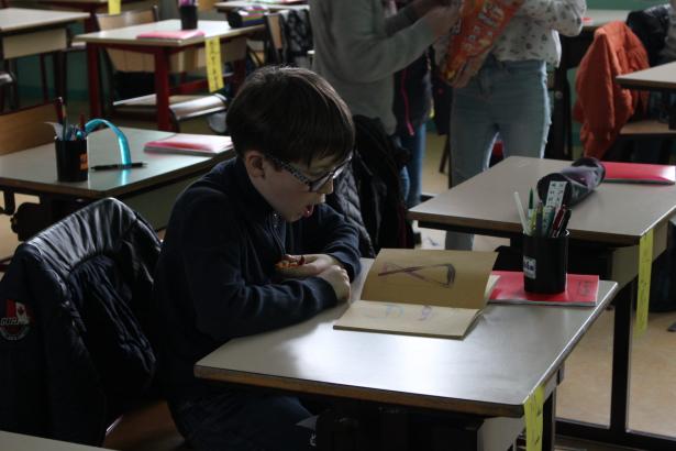 Mathéo en train de feuilleter un cahier de croquis que j'ai amené