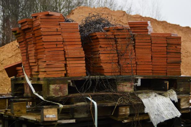 Tomettes entreposées devant le monticule de terre argileuse