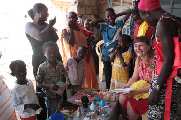 "Chaque femme prend le temps d’observer cette table de troc, de choisir un objet et de réfléchir à ce qu’elle veut troquer. Elles sont assises pour la plupart autour de la table, les enfants sont debout."