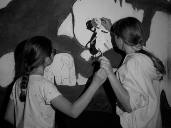 Les élèves projetant et reportant leur marionnettes dans l'espace de la grotte.