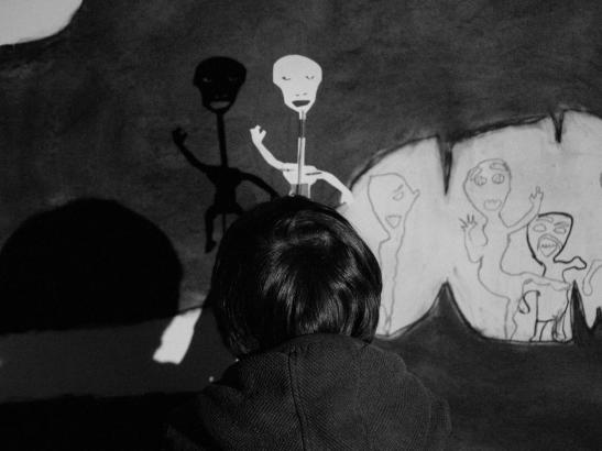 Les élèves projetant et reportant leur marionnettes dans l'espace de la grotte.