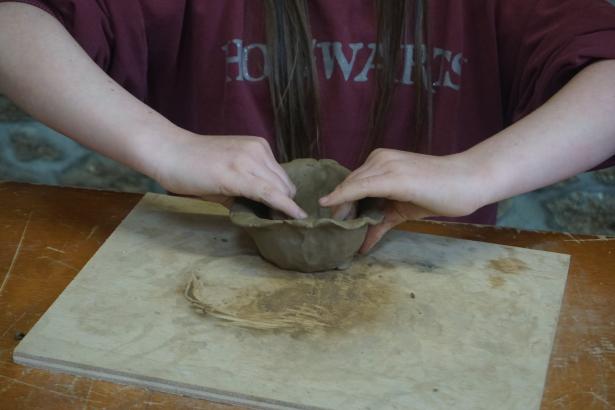 Modelage d'un pot à adventices dans une argile récoltée. 