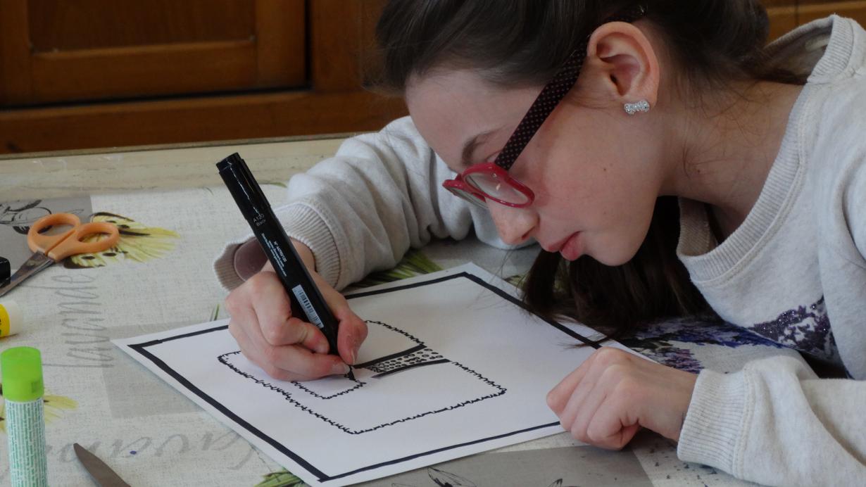 Une élève se concentre sur le dessin de son plan de la place Jeanne d'Arc