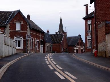 Les modestes maisons en briques du village entourent la place et l'église centrales.