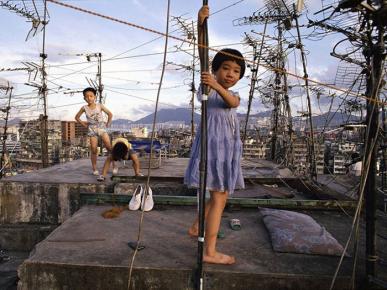 Photo couleur de deux enfants au dessus de l'ancienne cité de Kowloon.