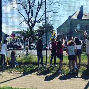 Performance de tissage sur les grilles de l'école 