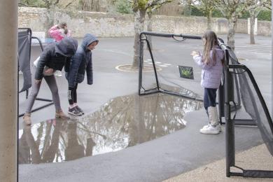 Les enfants pendant une "chasse au reflet" dans la cour de l'école