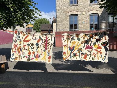 Tentures en feutres "1001 Fleurs" en laines de brebis Limousines et teintures naturelles - réalisées en juin 2024 avec les élèves de la classe CM2 de l'école élémentaire Ferdinand Buisson - crédits : Clara Salomon 